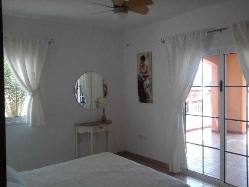 a bedroom with a bed and a mirror and a window at Sol y Luz in Caleta De Fuste