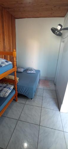 a small room with two beds in a room at Pousada Três Forquilhas in Guananazes