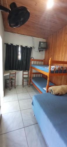 a room with two bunk beds and a table at Pousada Três Forquilhas in Guananazes