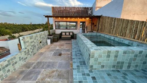 a swimming pool with a tile floor and a house at Piticcaia Lodge - Casa pé na areia, Frente mar - PREÁ in Prea