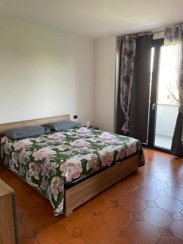 a bedroom with a bed with a floral bedspread at Appartamento vicino Rho Fiera in Cornaredo