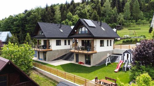 an aerial view of a house with a playground at FAJNE CHATY - rodzinny wypoczynek w górach in Falsztyn