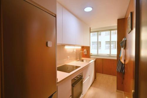 a kitchen with white cabinets and a sink and a window at Apt 40 m2 air conditioning radiant heating in Vigo