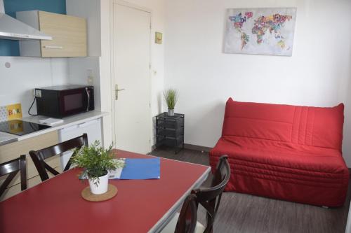 a living room with a red couch and a table at Appart-alma in Saint-Laurent-sur-Sèvre