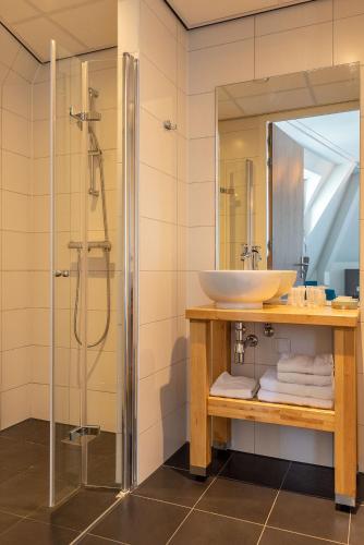 a bathroom with a sink and a shower at Hotelletje de Veerman in Oost-Vlieland