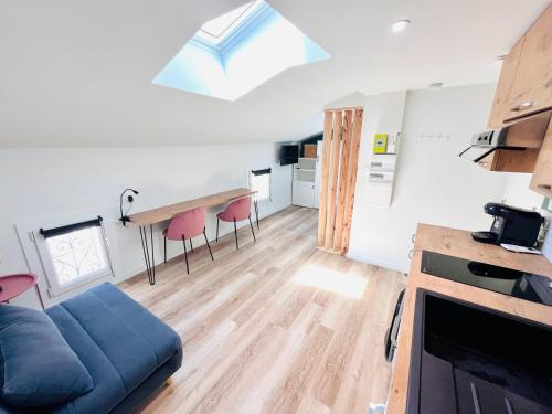 ein Wohnzimmer mit einem blauen Sofa und einem Tisch in der Unterkunft LE QUAI 6 - Studio neuf CALME LUMINEUX - CLIM - WiFi - Gare à 200m in Agen
