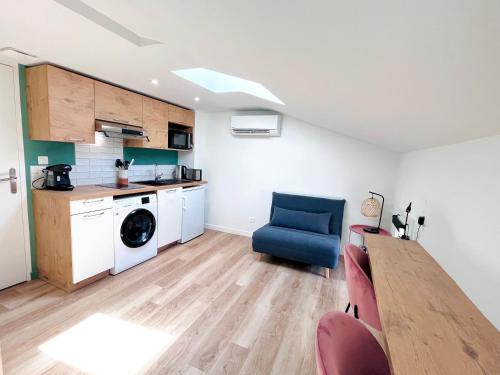 - une cuisine avec une table et une chaise bleue dans la chambre dans l'établissement LE QUAI 6 - Studio neuf CALME LUMINEUX - CLIM - WiFi - Gare à 200m, à Agen