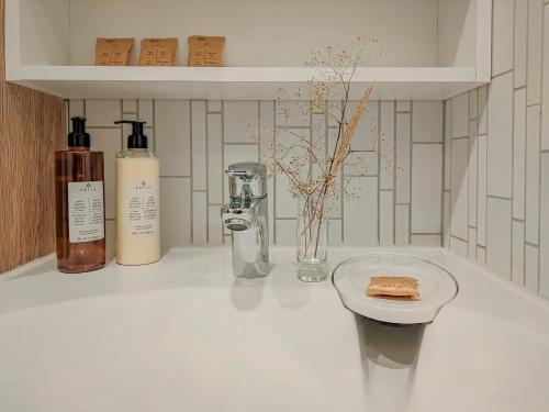 a white counter with two bottles and a plate of food at Comfy Rest apartamentai Kalno namuose in Juodkrantė