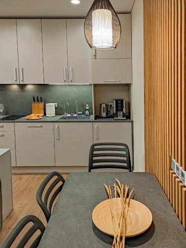 a kitchen with a table and some chairs and a counter at Comfy Rest apartamentai Kalno namuose in Juodkrantė
