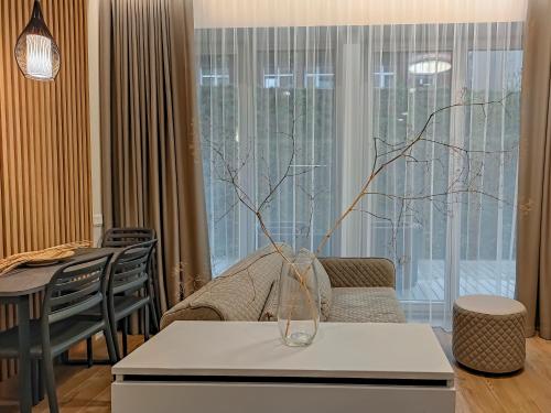 a living room with a vase on a table at Comfy Rest apartamentai Kalno namuose in Juodkrantė