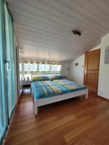 Cama grande en habitación con suelo de madera en Ferienwohnung Bally, en Brunnen