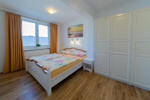 1 dormitorio con cama y ventana en Komfort Ferienwohnung Steiger, en Timmendorfer Strand