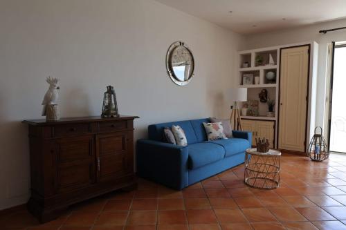sala de estar con sofá azul y espejo en Terrazza Miracapri en Pozzuoli