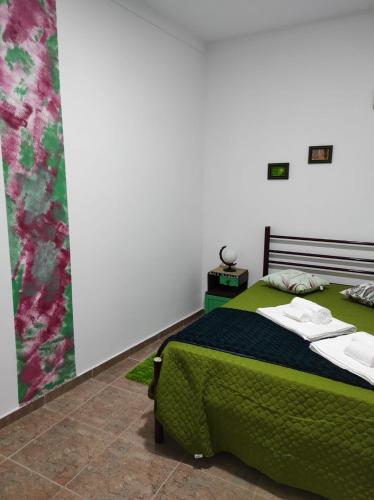 a bedroom with a bed with a green blanket at Mansão Alentejana AL in Alvalade