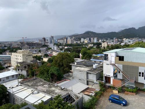 an aerial view of a city with buildings and a blue car at MountView studio in city in Port Louis