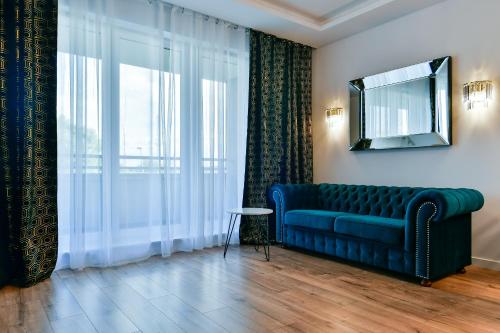 Apartament32 Golden Vip -Duże Miejsce Postojowe- في أولشتين: غرفة معيشة مع أريكة زرقاء ونافذة