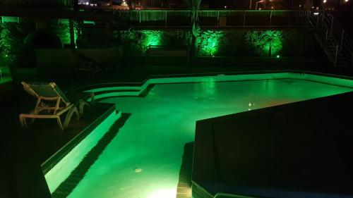 a swimming pool at night with a chair in it at viktoryadream in Eilat