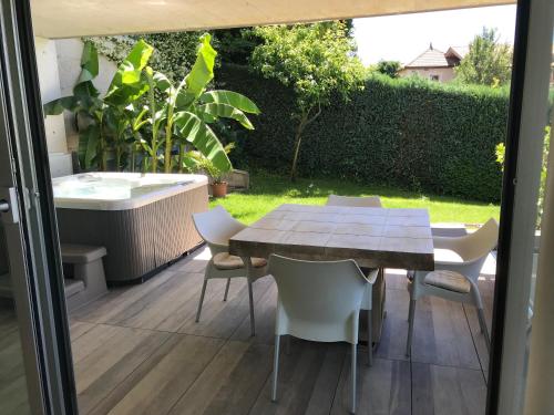 a patio with a table and chairs and a bath tub at Villa Alvarium in Schenna
