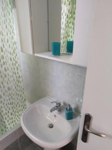 a bathroom with a white sink and a mirror at ARETI4 in Petalidi