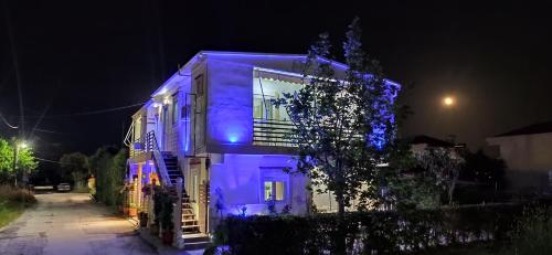 a house with blue lights on the side of it at Kostas Apartments in Kourouta