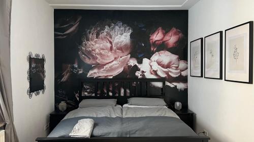 a bedroom with a large painting of flowers on the wall at Designerwohnung Afrika sehr zentral gelegen in Hannover