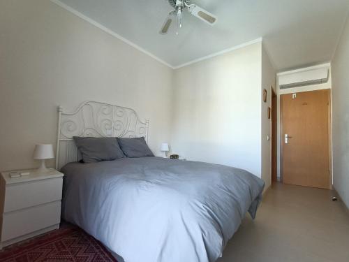 una camera da letto bianca con un letto e un ventilatore a soffitto di Royal Cabanas Beach by Amandio Batista a Cabanas de Tavira