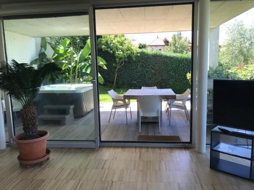 a patio with a table and chairs and a tub at Villa Alvarium in Schenna