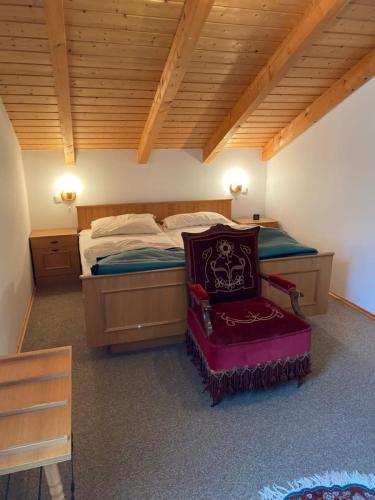 a bedroom with a bed with a chair in it at Ferienhaus im Waldferiendorf Regen in Regen