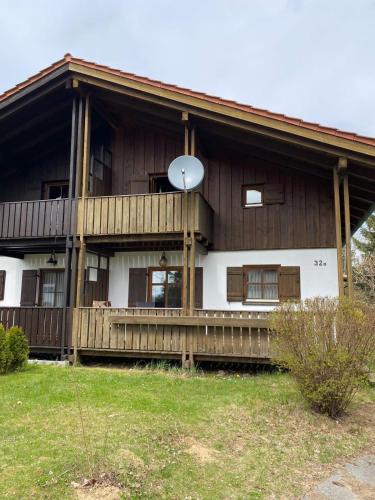 a large wooden house with a satellite at Ferienhaus im Waldferiendorf Regen in Regen