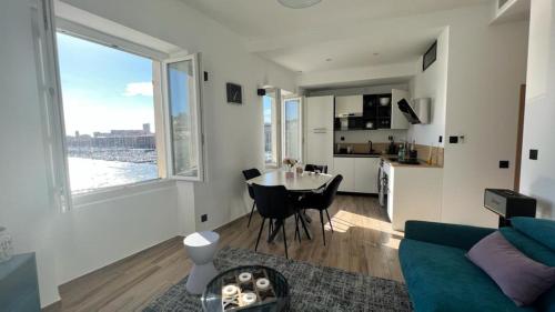 un salon avec un canapé et une table et une cuisine dans l'établissement Face au Vieux Port Vue 180 de Notre Dame au Panier, à Marseille