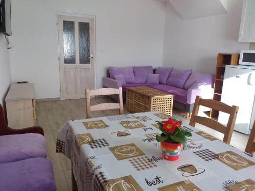 a living room with a table and a purple couch at Ubytování ve Starém Dvoře in Třemošnice