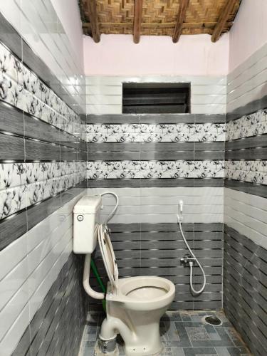 a bathroom with a toilet in a room at Prajwal home stay in Hampi