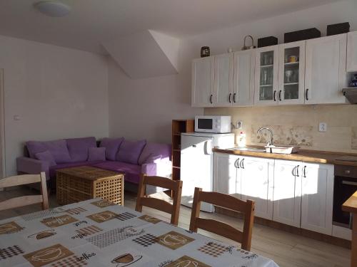 a kitchen and living room with a table and a purple couch at Ubytování ve Starém Dvoře in Třemošnice