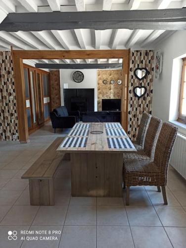 un salon avec une table et des chaises en bois dans l'établissement Le petit palais de NaCo aux portes d'Etretat, à Cuverville