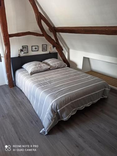 une chambre avec un grand lit dans un grenier dans l'établissement Le petit palais de NaCo aux portes d'Etretat, à Cuverville