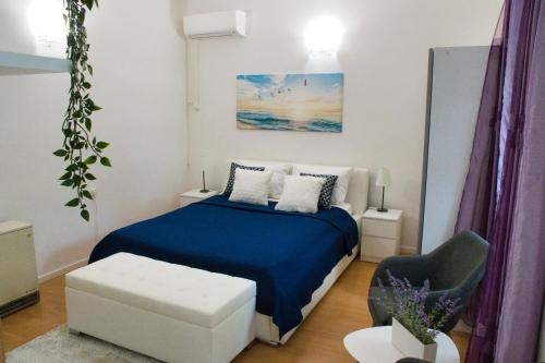 a bedroom with a blue bed and a chair at White Orchid Pula in Pula