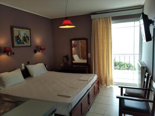 a bedroom with a large bed and a large window at Hotel Romantica in Loutra Edipsou