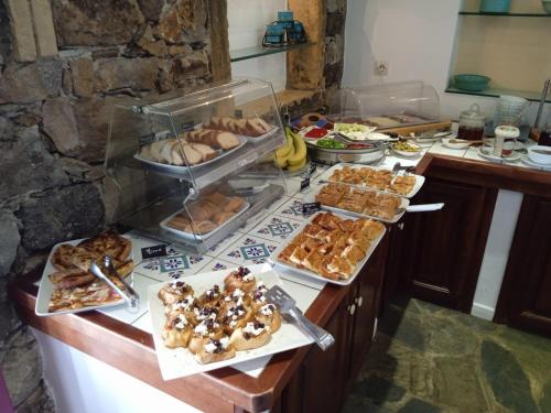 a buffet with many different types of pastries on a counter at Nefeli Hotel Leros in Agia Marina