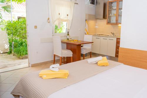 a kitchen with a bed and a table with yellow towels at Eleonora Apartments in Zadar