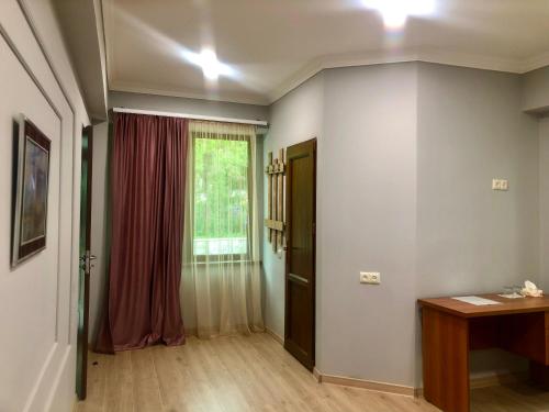 a room with a door and a window and a table at Guest House Anahit Ijevan in Ijevan