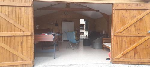 eine offene Scheunentür mit einem Tisch und einem Schreibtisch in der Unterkunft Vacances a la campagne mobil home tout confort , chalet avec barbecue, in Javron-Les-Chapelles