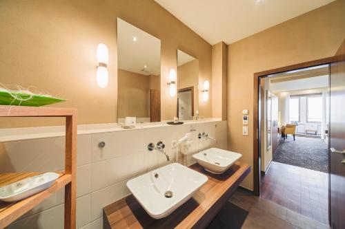 a bathroom with two sinks and a large mirror at Flair Hotel zum Schiff in Meersburg