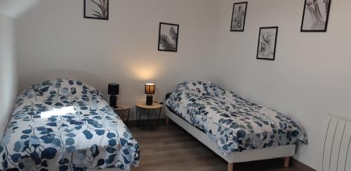 sypialnia z dwoma łóżkami i obrazami na ścianie w obiekcie Gîtes des 4A w mieście Sémeries