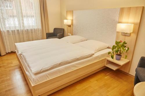a bedroom with a large bed with white sheets at Flair Hotel zum Schiff in Meersburg