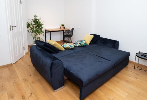 a blue couch with pillows on it in a living room at Lossi 32 Luxury Apartment with Sauna in Tartu