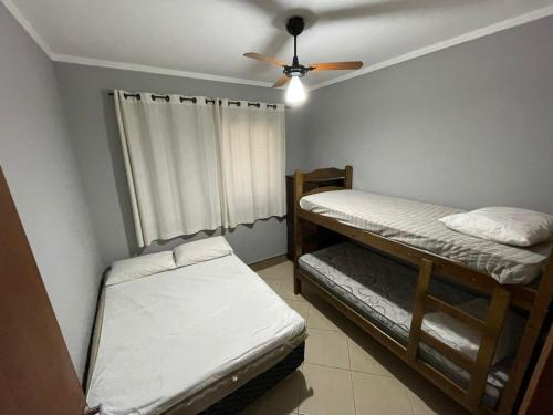 a room with two bunk beds and a ceiling fan at Chácara em Boituva condomínio fechado in Boituva