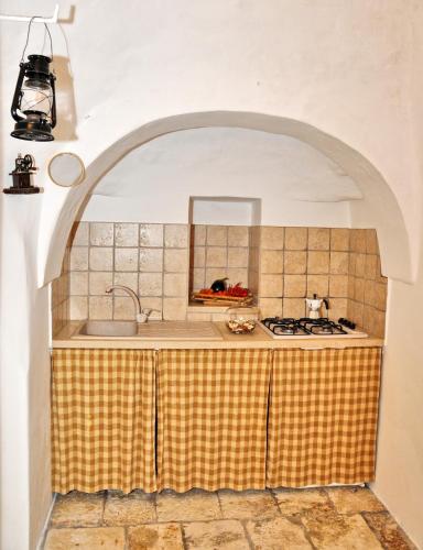 a kitchen with a sink and a stove top oven at Trulli Vulés in Ostuni