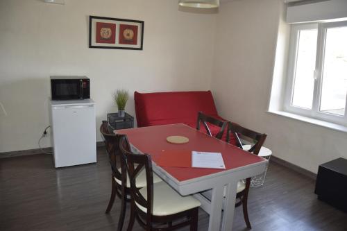 a small kitchen with a red table and chairs at Appart-alma in Saint-Laurent-sur-Sèvre