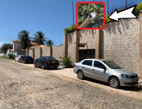 a car parked next to a brick wall with a camera at Pousada Oasis Paracuru in Paracuru