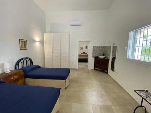 a bedroom with two beds and a room with a sink at Casale Montereale in Corato